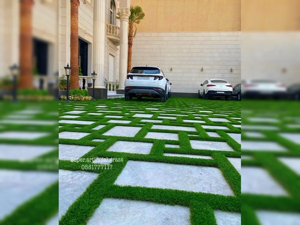 ممر سيارات بعشب صناعي بين بلاط حجري أبيض